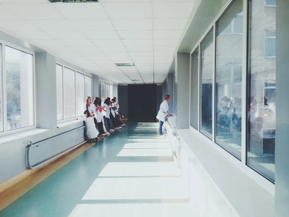 Klinik koridoru: geniş pencerelerden gün ışığı alan aydınlık hol